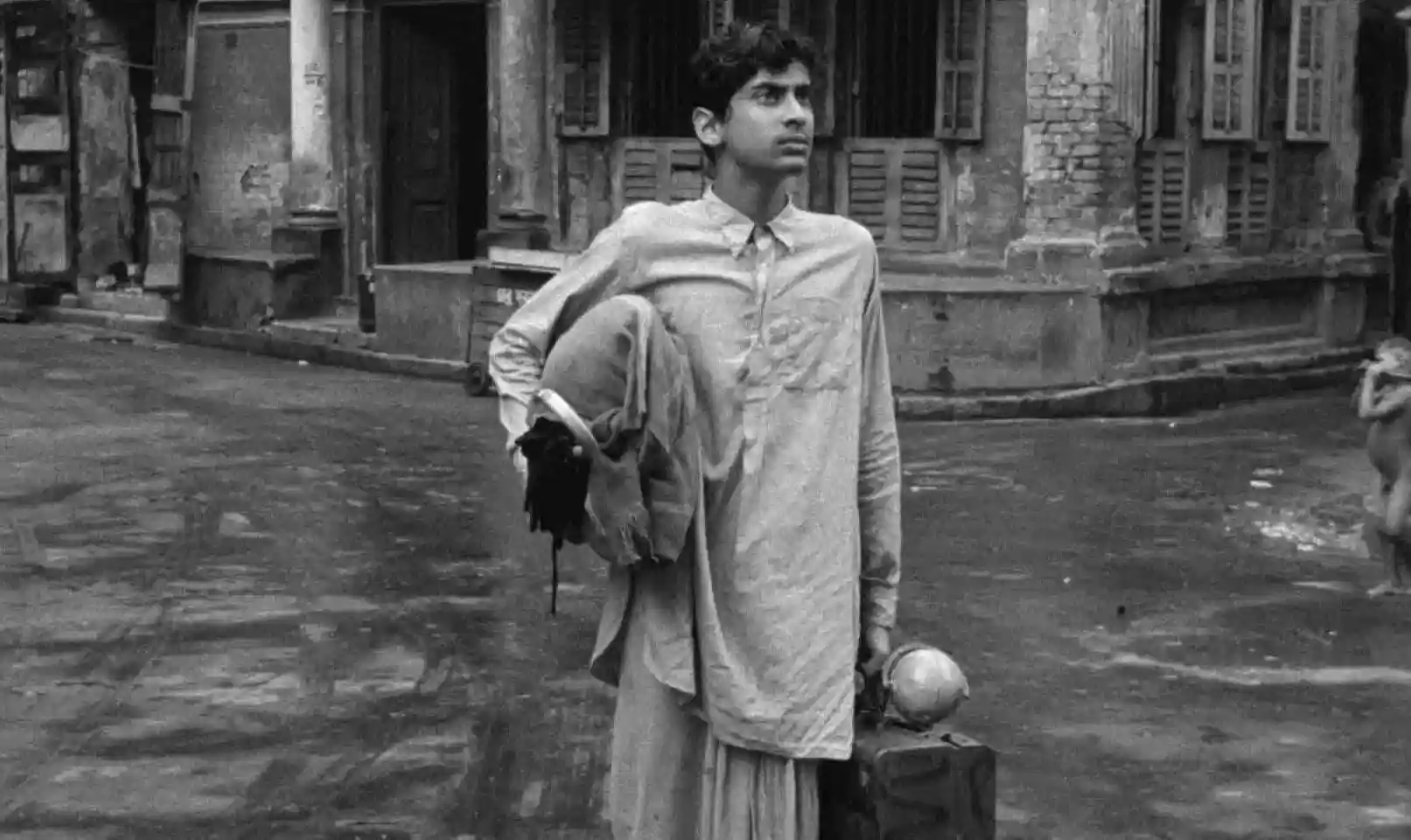 A young adult named Apu arrives in Calcutta for college, briefcase in hand.