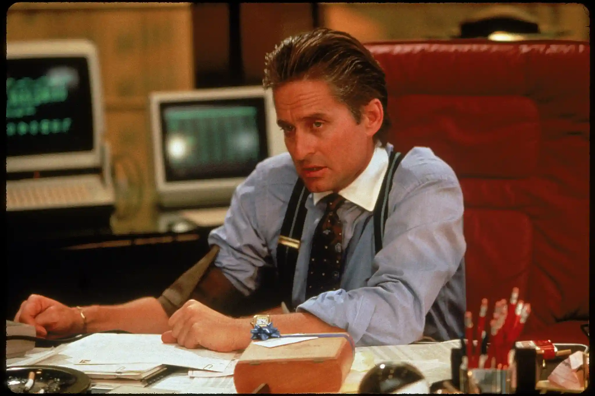Michael Douglas sits exhausted at his desk on Wall Street.