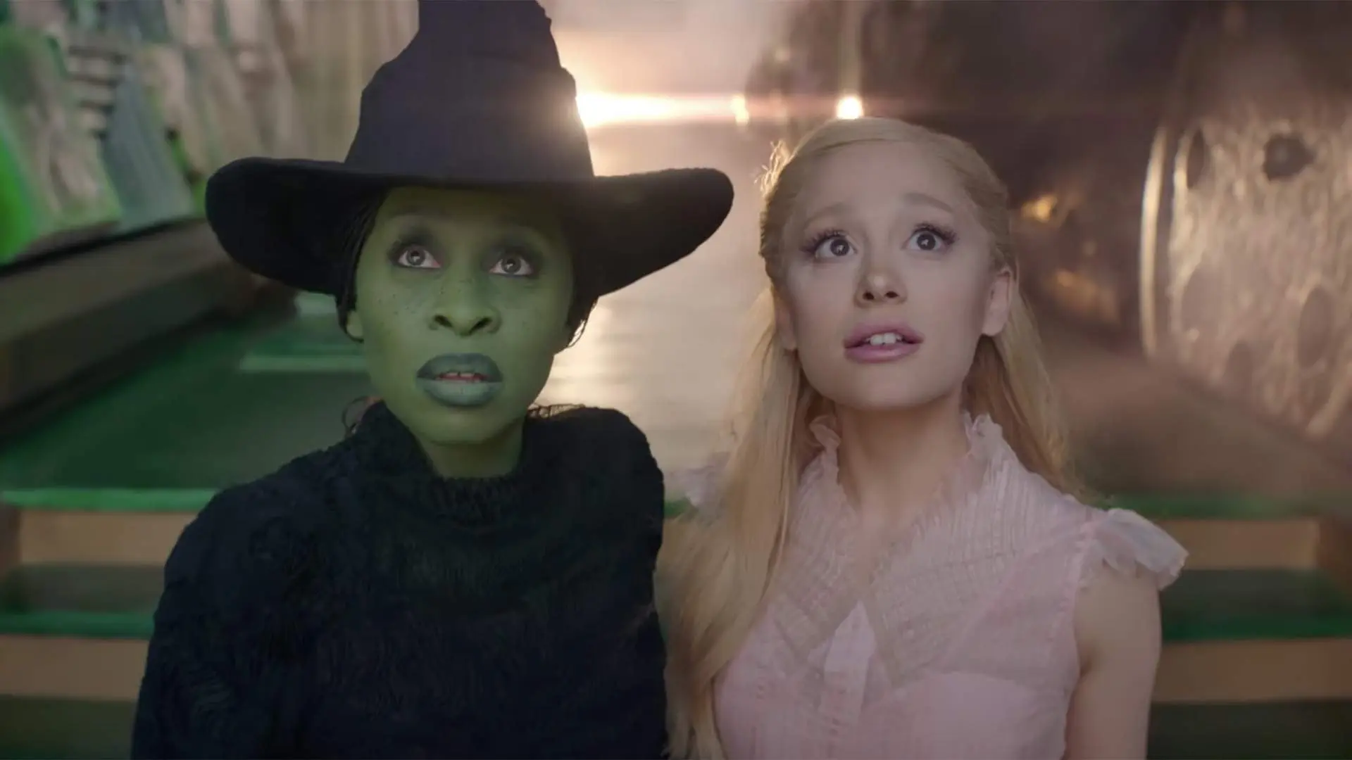 Elphaba and Glinda look up in The Wizard of Oz's building.